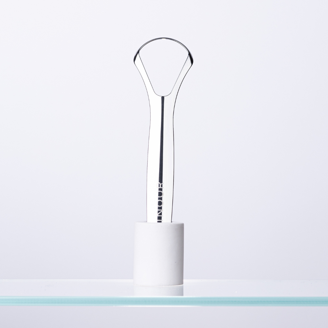 Eternal tongue scraper in holder on glass shelf