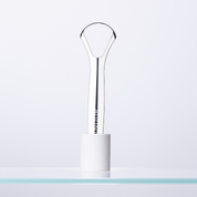 Eternal tongue scraper in holder on glass shelf