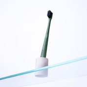 Toothbrush in holder from below on glass shelf