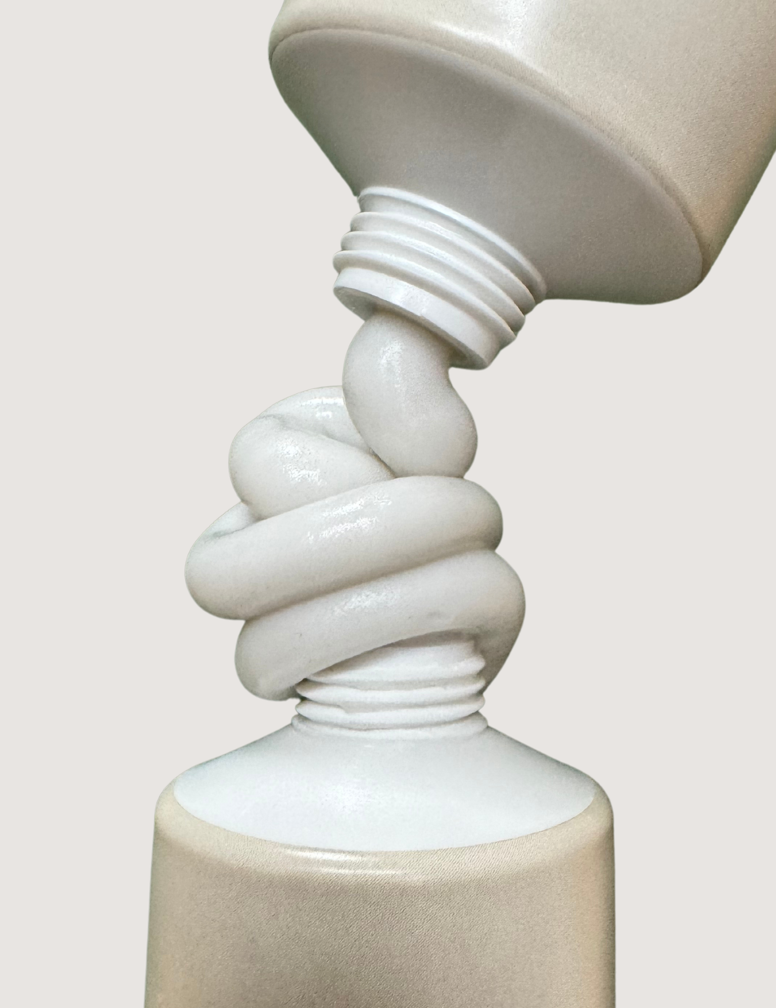 Two beige toothpaste tubes squeezing out toothpaste