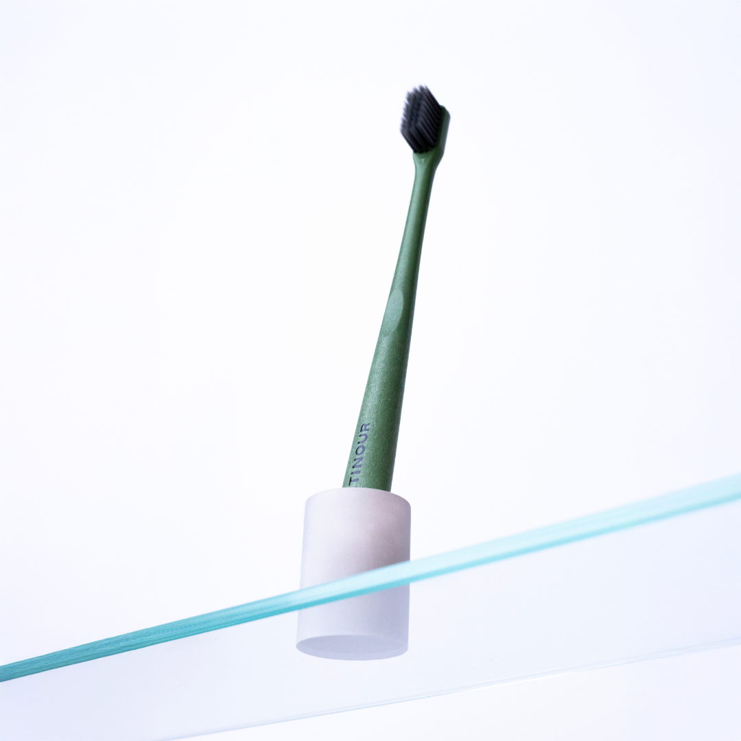 Toothbrush_in_holder_from_below_on_glass_shelf.png