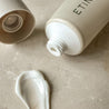 Etinour essential whitening toothpaste tube, formula and cap on beige stone