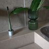 Etinour essential toothbrush in clean bathroom with green plant